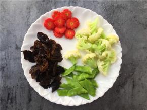 将胡萝卜切片，荷兰豆去筋切两半，黑木耳洗净拆小块。