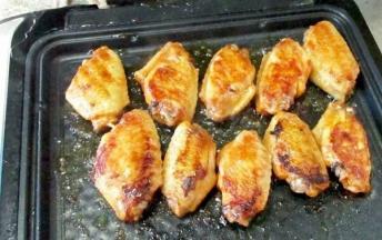 烤盘加热，放油，放入腌制好的鸡翅，小火煎，一面5到8分钟，煎至两面金黄用牙签轻松捅进去就是熟了。