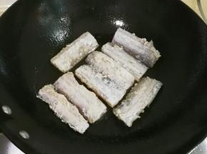 放入带鱼煎至金黄