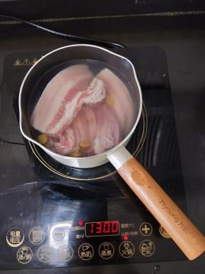 五花肉冲洗干净，分成两份放到水里，然后加入适量料酒、姜和一丢丢盐，烧开后再煮五六分钟。