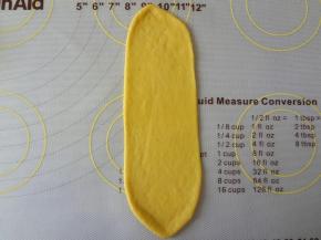 取出称重排气分割成12个23克的面团，6个49克的面团，小面团松弛10分钟，大面团松弛20分钟，取松弛好的小面团擀成牛舌状