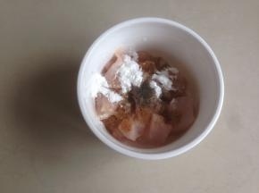 往鸡肉里倒入盐、黑胡椒粉、孜然粉、花生油、2克玉米淀粉和10克蛋清