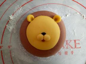 取2份0.5克黄色面团和一点点黑色面团做出狮子的鼻子部位，