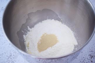 把材料除了黄油外，都放入和面桶，顺序为纯牛奶、鸡蛋液、糖和盐对角放，然后放面粉，酵母放最上面