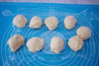 取出面团按压排气揉均匀分成9份，盖上保鲜膜醒发15分钟