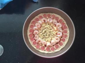 15、码上一圈虾仁，均匀地撒上黑胡椒碎，再均匀地撒上一层马苏里拉奶酪。