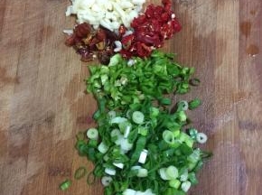 蒜瓣一个薄皮剁碎，干辣椒切成段，青红辣椒切成圈儿，葱切成葱花备用。