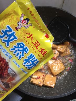 放入两勺小丑娃孜然粉翻炒均匀。