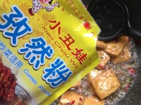 放入两勺小丑娃孜然粉翻炒均匀。