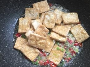 加入少许的水，放入煎好的臭豆腐翻炒均匀。