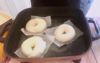 发酵剩5分钟时，准备糖水，1000克水50克糖，大火烧水，看到水底有小气泡产生的时候，立马转小火，维持半开的水温。不要烧开（水温最好80-90度，也就是说不是煮面团，而是烫面团）。将发酵好的面团取出，放进糖水，可以手托油纸，将油纸和面团一起放进糖水锅，这时油纸自然会掉落，捞起来就好了。面团每面煮30秒，再捞出沥去多余水分。