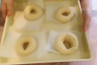 依次完成所有。放在比贝果大一点的油纸上，放在温暖处（大概30-35度）进行发酵30分钟。发酵时保证一定湿度但不要盖湿布，盖了湿布后贝果面团表皮会变湿，在煮面团时会立马收缩。