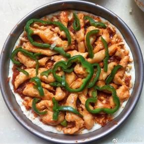 披萨饼皮上放番茄酱，鸡脯肉，青椒段