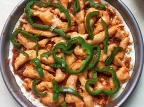 披萨饼皮上放番茄酱，鸡脯肉，青椒段