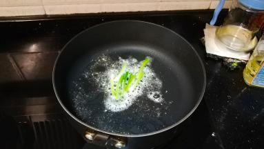 锅里热油放入葱段、蒜盐
