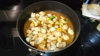 倒入生蚝、虾粒放入料酒、盐、酱油、糖，生蚝会出汁水