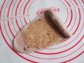 将醒发好的面团擀成长舌状，将红糖均匀铺在面饼上面，从一侧卷起，收口捏紧。