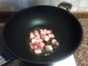 放入五花肉翻炒至变色微出油且表皮发黄。