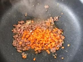 待牛肉变色后，放入胡萝卜。