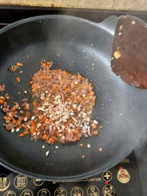 翻炒均匀后加入香菇丁。