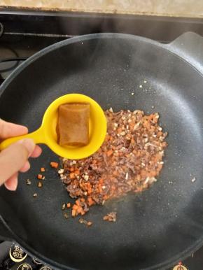 然后再加入咖喱和一点点热水，翻炒均匀后焖一分钟左右。