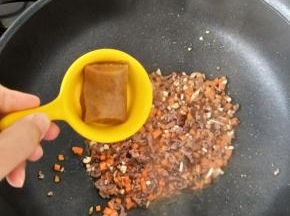 然后再加入咖喱和一点点热水，翻炒均匀后焖一分钟左右。