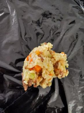 待炒饭稍微晾凉后，在桌面铺一张保鲜膜，放上适量炒饭。