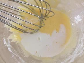 4.加热的牛奶分次加入到蛋黄糊里搅拌均匀。