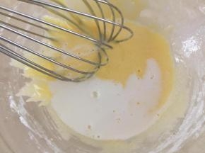 4.加热的牛奶分次加入到蛋黄糊里搅拌均匀。
