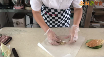 11.取一份挤上卡士达酱（底部那面），底部铺好油纸，从一个角卷起，定型，装入包装盒中。