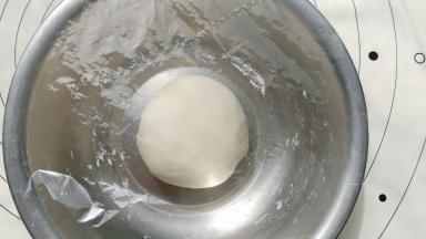 放入盆里盖保鲜膜放温暖处醒发20分钟左右。