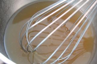 制作饼皮：将转化糖浆和枧水先倒入盆里，搅拌匀后加入花生油，继续搅拌至乳化状态。