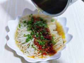 将蒸熟的金针菇取出，把切好的青椒撒在金针菇上面，再把烧热的油淋在上面。