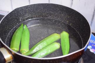 锅中烧开水滴入少许食用油和盐，再放入秋葵焯至颜色变翠绿后捞出过凉水