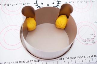 取小熊耳朵部分的面团揉匀揉圆放入小熊模具的耳朵的位置