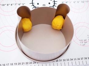 取小熊耳朵部分的面团揉匀揉圆放入小熊模具的耳朵的位置