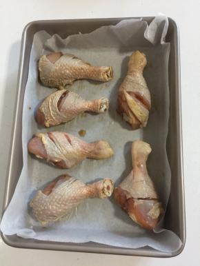 取一个深烤盘，铺上一层油纸（或锡纸），把腌制好的鸡腿放在烤盘里。