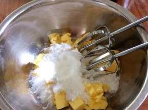 糖粉倒入黄油盆，用打蛋器搅拌一下，先低速再转中高速打发到体积蓬松，颜色发白的羽毛状