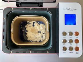 把蝶豆花水、糖、盐、高筋面粉和酵母放入柏翠面包机的面包桶中，启动和面程序，揉面15分钟。