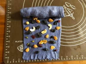 先把无花果干卷起，剩余的面团摆上其余的干果和坚果。