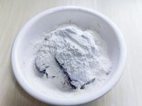 炒熟的糯米粉倒入紫薯泥中，搅拌均匀后再揉成团。