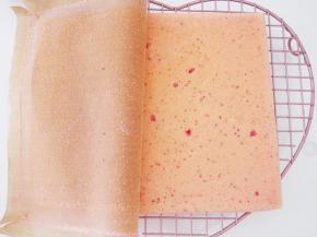 烤好的蛋糕片扣在晾网上，撕掉油布后盖上一张油纸，晾至温热。