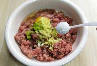 将切好的葱姜蒜末加入肉糜中，加入盐。