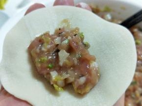 取一张饺子皮，放入适合的馅料。(饺子皮我是超市买的，如果自己和面，擀饺子皮也可以呦～)