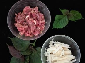 牛肉切成薄片，加入适量料酒、盐、淀粉、酱油、姜丝，搅拌均匀后腌半个小时左右。酸笋也切成条备用。