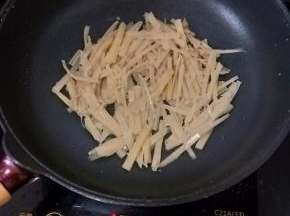 锅烧热不用放油，直接倒入酸笋，小火炒干水分，这样酸笋会更香。