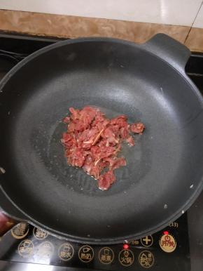 把酸笋盛出来后，放适量油，下牛肉，大火快速翻炒。