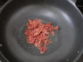 把酸笋盛出来后，放适量油，下牛肉，大火快速翻炒。