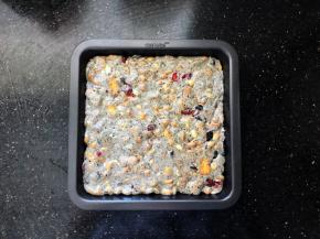 10、倒入学厨不粘烤盘中，待稍凉后按压平整后放入冰箱冷冻一个小时后取出，撒上一层薄薄的奶粉，用锋利的刀切成大小均匀的小块就可以了。