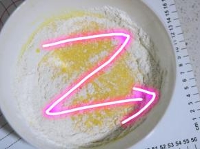将低粉筛入蛋黄液中，用划Z形拌匀低粉，拌好的蛋黄糊是无颗粒的流动状